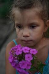 Fototapeta premium Photo of happy young woman in dress holding bouquet with flowers while walking outdoor. Selective focus