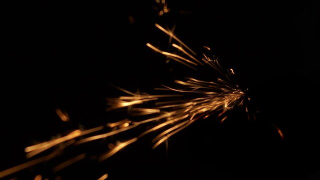 Fiery splashes of Bengal fire. Incendiary background for a greeting card. An essential attribute of a Merry Christmas. Slow motion blur and glare. Side view.