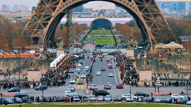 View of the Eiffel Tower in Paris from the Trocadero Square at sunset, France. Jena Bridge with multiple people and cars, Champ de Mars on the background