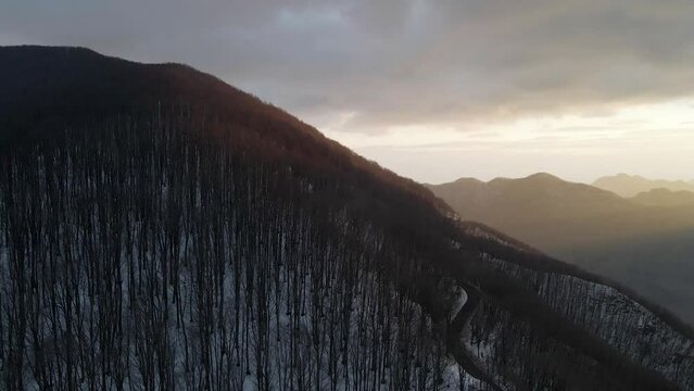 Aerial view of Mount Terminio landscape with snow in wintertime at sunset, Serino, Avellino, Irpinia, Campania, Italy.