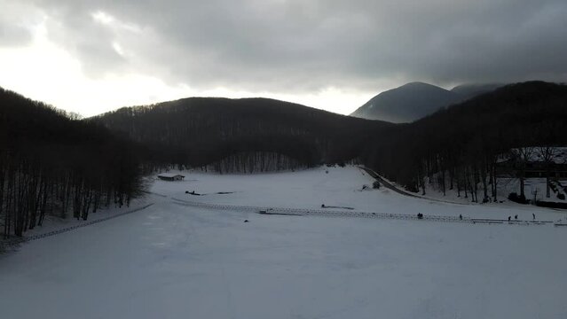 Aerial view of Verteglia Plateau with snow in wintertime at sunset on Mount Terminio, Serino, Avellino, Irpinia, Campania, Italy.