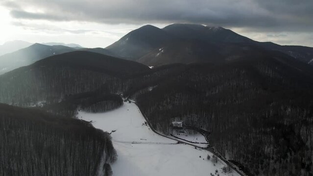 Aerial view of Verteglia Plateau with snow in wintertime at sunset on Mount Terminio, Serino, Avellino, Irpinia, Campania, Italy.