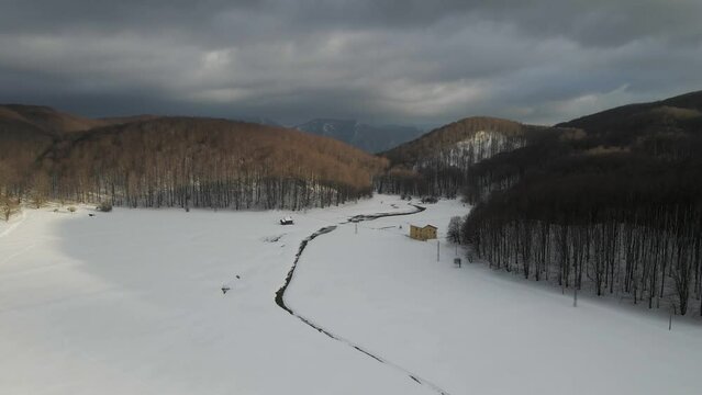 Aerial view of Verteglia Plateau with snow in wintertime at sunset on Mount Terminio, Serino, Avellino, Irpinia, Campania, Italy.
