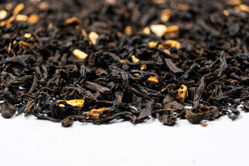 Black tea with orange peel and cinnamon close-up top view