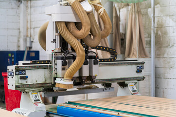 Wood CNC machine at carpentry workshop. Production line of the wooden factory. CNC automatic woodworking machine in manufacturing industry