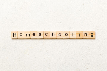 Homeschooling word written on wood block. Homeschooling text on cement table for your desing, Top view concept