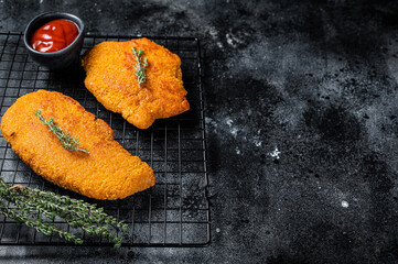 Fried Breaded weiner schnitzel, cooked meat steak. Black background. Top view. Copy space