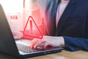 Businessman using laptop computer with alerts, warning triangles showing system errors. Concept of...