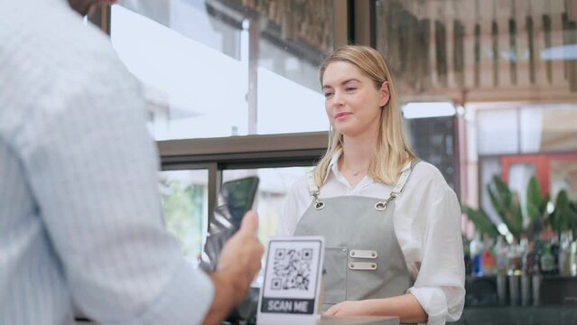 Female worker takes payment via QR code from a customer man who comes to shop, Cashless technology and online shopping concept