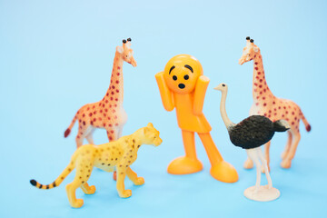 動物に囲まれて驚くカラフルな人形