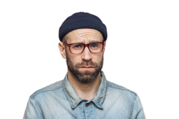 Grumpy bearded man with offended expression, being dissatisfied with something, frowns face, wears spectacles, hat and shirt, isolated over pink background. Displeasure and negativity concept