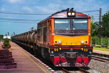 Fototapeta premium Tanker-freight train by diesel locomotive passed the railway station.