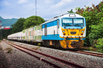 Freight train by diesel locomotive passed the railway station.