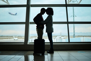 Airport, couple and silhouette of love, hug and leaving on vacation on a airplane flight. Plane departure, holiday and young people shadow by a window for journey, vacation break or immigration - obrazy, fototapety, plakaty