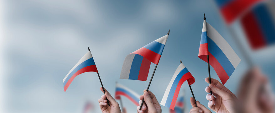 A group of people holding small flags of the Russia in their hands - Powered by Adobe