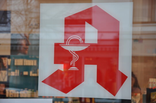 Deutsche Apotheken Logo: Das rote Zeichen f&uuml;r die Gesundheit und den Vertrieb von Arzneimitteln am Geb&auml;ude.