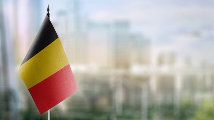 Small flags of the Belgium on an abstract blurry background