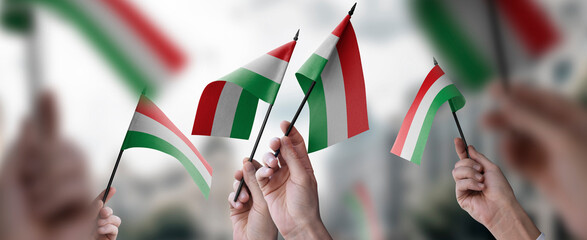 A group of people holding small flags of the Hungary in their hands