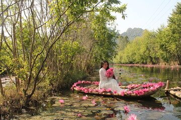 vietnam beautiful woman with ao dai especially in the Mekong Delta and water lilies flower