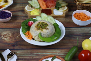 Fancy Ouzi Dinner with Vegetables and Dips - Filo Wrapped Rice Dish Served on Wooden Table in Restaurant