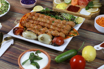 Grilled Meat Served with Salads, Sauces, Vegetables, Chips and Pita Bread