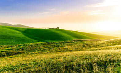 scenery rural view of a contryside farm in green fields and hills with amazing cloudy sky on background