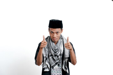 Religious muslim asian man wearing turban, muslim dress and cap, showing thumbs up that he agrees. Isolated on white background.