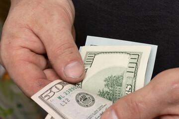 male hands holding dollar bills, counting money, 50, 100