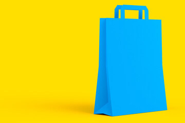 Folded kraft paper bag with handle isolated on yellow background.