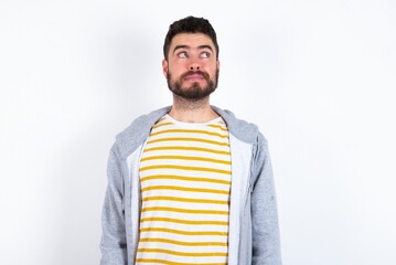 caucasian man wearing casual sportswear over white wall looking aside into empty space thoughtful