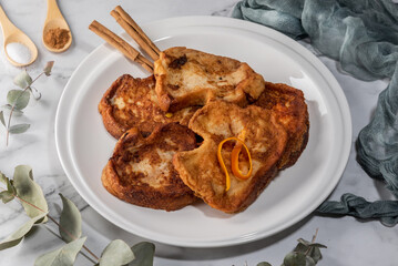 Set of torrijas on a marble countertop. Typical Spanish sweet made of bread, milk, eggs, sugar and cinnamon, consumed during Carnival and Easter