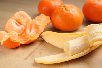 Fruit Background. Bananas, mandarines on wooden table. Ripe fruit on the wooden table. Healthy Fruits. The Vegetarian, Vegan, And Raw Food.