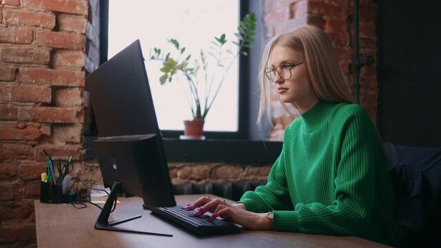 Woman Is Typing Text On Keyboard Of Modern Computer, Working In Modern Office With Loft Interior