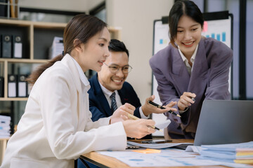 Obraz premium Business, technology and office concept - Asian team business with laptop, tablet pc computer and papers having discussion in modern office.