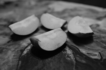 cut apple in four slices on polished marble table