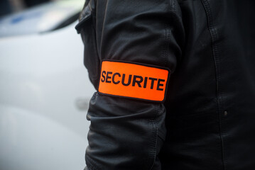 closeup of security sign on arm of security guard in the street