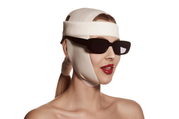 Female face bandaged with medical bandages and sunglasses with human emotions. Making beauty, modifying face to make surgical correction, plastic surgery. correction of asymmetry.