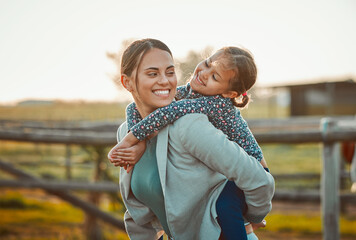 Fototapeta na wymiar Mother, young girl and hug of a kid piggy back fun and parent care outdoor in equestrian field. Mom smile, child happiness and family in nature with blurred background in summer on holiday in a park