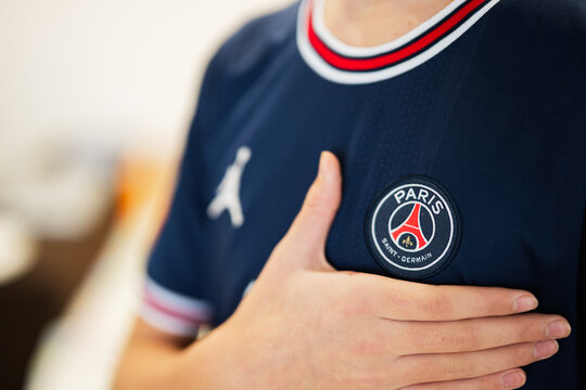 Ternopil, Ukraine - February, 2023: Boy put hand on heart, wear of PSG Paris Saint Germain football club uniform.