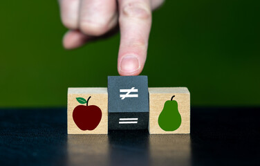 Symbol for the phrase that you can't compare apples with pears. Hand turns wooden cube and changes...