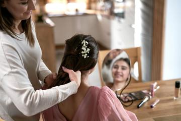 Caucasian mother help her daughter with preparing to prom