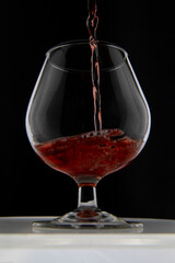 Pouring wine into a glass on a dark background