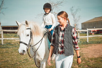 .Woman, child on horse and happy ranch lifestyle and animal walking on field with girl, mother and...