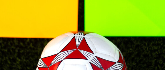 View of a soccer ball on the grass with two blank cards. Soccer ball on the grass with copy space.