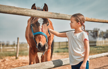 .Girl child, touch horse and outdoor with care, love and holiday at farm, countryside or zoo in...