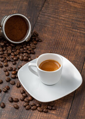 Fresh espresso coffee together decorated with coffee beans on wooden table
