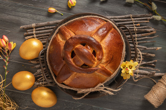 Portuguese traditional Easter cake. Folar with golden eggs on easter table. Blossom flowers and golden painted eggs.