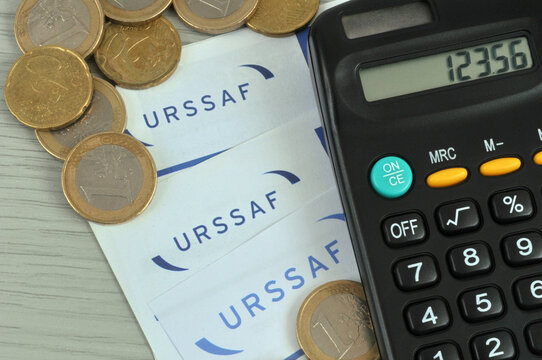 Formulaires de l'URSSAF avec une calculatrice et des euros