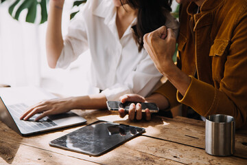 Entrepreneur Asian businessman and businesswoman discussing new business project in tablet in modern Meeting In Modern Office, Asian business casual concept.