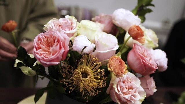 florist making the bouquet of flowers in a flower shop